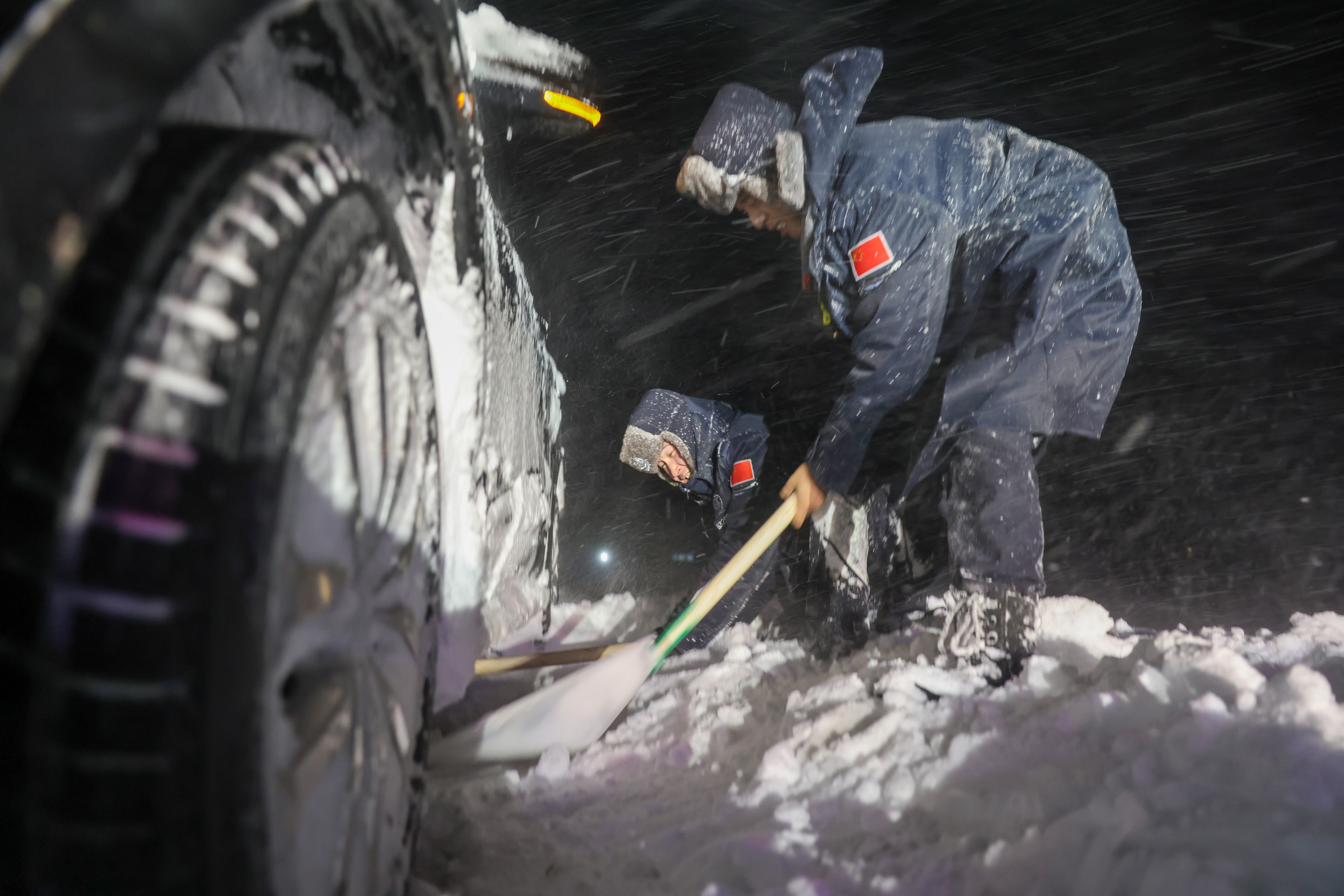 6图为 2025年11月13日，新疆阿勒泰边境管理支队吐尔洪边境派出所民警正在清理被困车辆周边的积